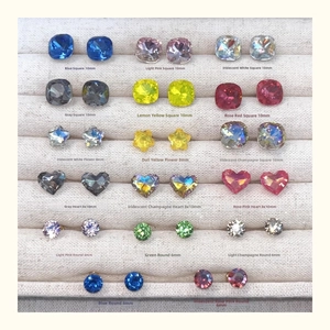 Detail view of colorful crystal stud earrings in heart, square, and star shapes