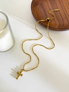 Close-up of gold-plated titanium steel beaded chain with spherical cross pendant and clasp