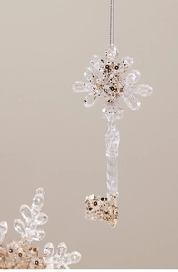 Detailed view of a transparent key ornament with sparkling silver and gold sequins inside