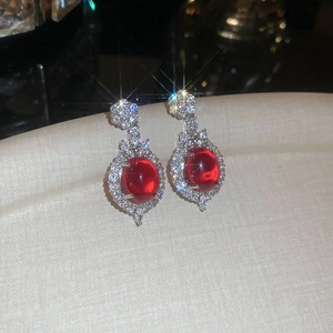 Macro shot of vintage style red oval gemstone earrings with sparkling crystal border