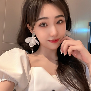 Elegant white organza flower earrings with pearl drop pendant on a professional model