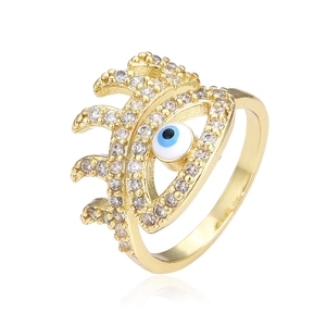 Gold evil eye open ring featuring clear zircons and blue enamel detailing on white background