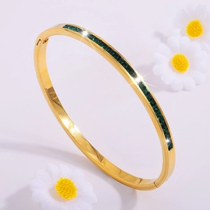 Elegante brazalete de acero de titanio dorado con piedras rectangulares verde esmeralda
