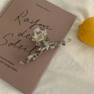 Chic marble pattern hair claw clip on vintage book and lemon for a French elegant look