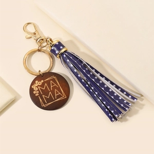 Close-up of MAMA wooden tag keychain with gold ring and blue star PU leather tassel