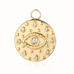 Macro view of golden evil eye pendant with clear crystal and textured details