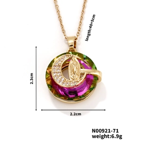 Detail of gold necklace pendant with purple and green crystals and crescent moon charm