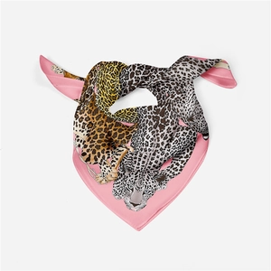 Detail of pink silk scarf featuring a stylish leopard print pattern and smooth texture