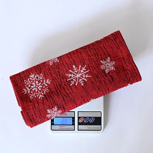 Detailansicht des roten Strick-Weihnachtstischläufers mit einem Gewicht von 287g auf der Waage