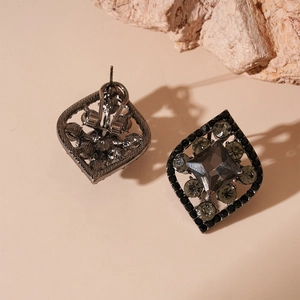 Macro view of gunmetal geometric diamond earrings with crystal inlay and omega clip back