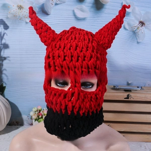 Close-up of red and black knit balaclava with horn details for Halloween party costume