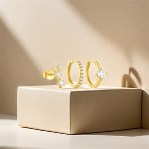Detailed view of three-piece gold S925 silver earring set with clear cubic zirconia accents