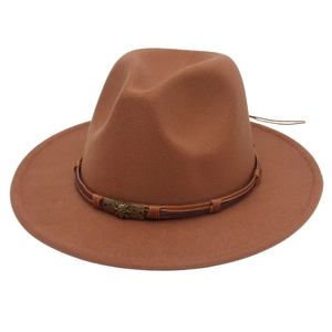 Close-up of brown wool fedora hat with skull emblem on decorative leather band