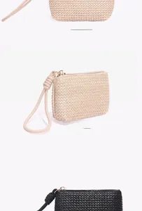 Close-up of woven straw coin purse with zipper and wrist strap in beige and black