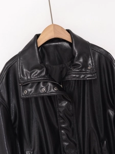 Detail of high neck faux leather bomber jacket showing collar and shoulder texture