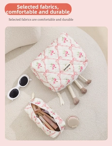 Quilted floral makeup bag set with rose patterns and bow details on white plush surface