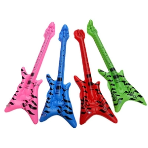 Detail of four colorful inflatable guitars in pink blue red and green with flame patterns
