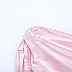 Gros plan détaillé d'une robe en satin rose avec fronces élégantes et détails d'épaule