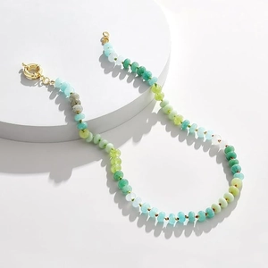 Detail of bohemian beaded necklace with mint green and blue stones and gold clasp