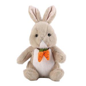 Cute beige plush bunny toy sitting with orange carrot decorations on white background