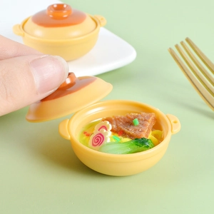 Detailed macro view of a miniature dollhouse ramen noodle pot with tiny food toppings