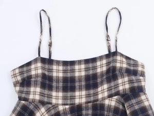 Close-up of blue and brown plaid fabric texture with precise stitching and thin strap