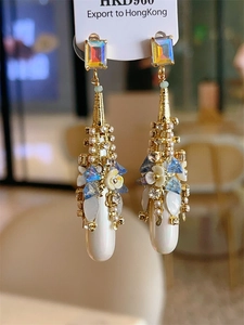 Detail of bohemian gold teardrop earring with rectangle crystal and flower cluster