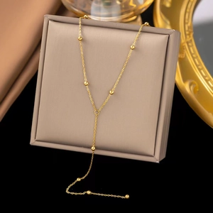 Detail of 18K gold-plated Y-shaped titanium steel necklace with round metallic beads