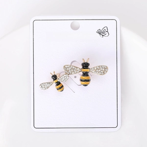 Detail of bee pins with yellow enamel and sparkling rhinestones on a white card