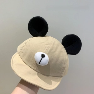 Macro detail of the plush bear ears and snout on a beige baby soft brim baseball cap