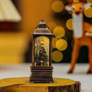 Golden Christmas lantern ornament with miniature tree and warm LED lighting display