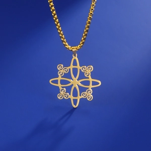 Macro shot of golden Viking spiral pendant with intricate cut-out patterns on blue background