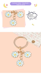 Close-up of cute light blue daisy pendants with golden key ring and floral card