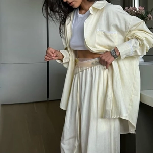 Détail de l'ensemble deux pièces chemise à manches longues rayée jaune clair et pantalon large