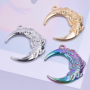Detailed engraving on moon-shaped stainless steel flower pendants in gold, silver, and rainbow
