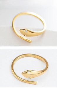 Detailed view of an adjustable golden snake ring with sparkling white gemstone eyes