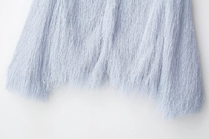 Close-up of light blue fringe hem on a casual jacket showing soft fiber texture