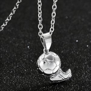 Macro shot of silver soccer ball and cleat pendant charms on a delicate link chain
