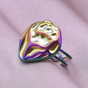 Macro shot of rainbow gradient paw print ring on soft pink silk background