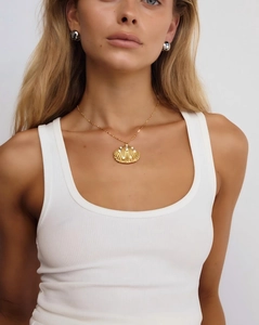 Golden shell pendant necklace with sparkling stones worn by a professional model