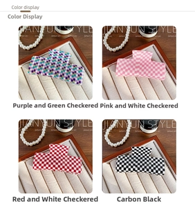 Close-up of four checkerboard acrylic hair claws in purple, pink, red, and black patterns