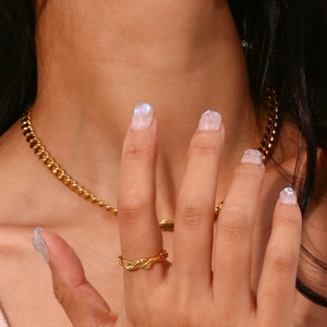 Detailed view of irregular 18K gold plated ring and Cuban chain necklace on model
