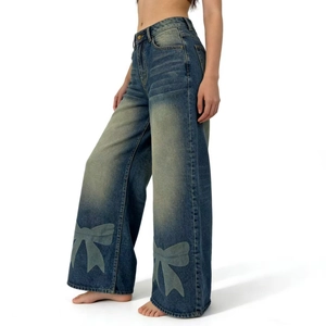 Vue détaillée du jean large bleu avec délavage vintage et motif imprimé de nœuds papillon