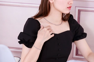 Close-up of silver Figaro chain necklace and bracelet set worn by a fashion model