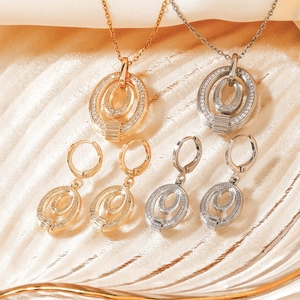 Close-up of gold and silver jewelry sets with oval stone pendants and matching earrings