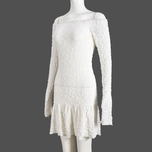 Detail of white off-shoulder mini dress featuring unique 3D bubble textured fabric and ruffled hem