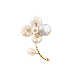 Macro detail of bouquet brooch with natural baroque pearls and white enamel flower