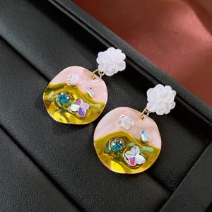 Floral resin earrings with colorful enamel pendants and butterfly crystal accents