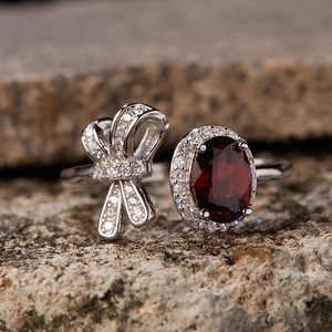Macro shot of S925 silver ring with red garnet stone and diamond bow detail