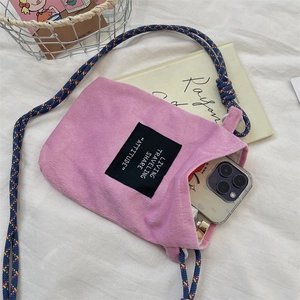 Pink corduroy mini crossbody phone bag with woven strap shown with a smartphone inside